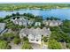 Aerial view of colorful townhomes, lake, and community pool, surrounded by mature trees at 3280 Soho St # 306, Orlando, FL 32835