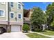 Townhome exterior with attached garage and a tree with vibrant pink blossoms at 3280 Soho St # 306, Orlando, FL 32835