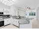 Open kitchen with stone countertops, modern appliances, and a view of the living area at 3280 Soho St # 306, Orlando, FL 32835