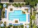 Aerial view of community pool with poolside seating, mature landscaping, and shade structures at 3280 Soho St # 306, Orlando, FL 32835
