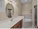 Bright bathroom features a large oval mirror, marble countertop, and a soaking tub with tiled surround at 336 E Kaley St, Orlando, FL 32806