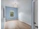 This bright bedroom has hardwood floors, neutral paint, a large window, and a modern light fixture at 336 E Kaley St, Orlando, FL 32806