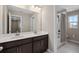 This bathroom has double sinks, a dark vanity, white tile floors, and a tub with shower at 3990 Bannock Ave, Tavares, FL 32778