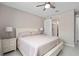 Neutral bedroom featuring a ceiling fan, a sliding barn door to the bathroom, and light wood furniture at 3990 Bannock Ave, Tavares, FL 32778