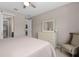 Bright bedroom featuring a mirrored dresser with drawers and a comfortable chair in neutral decor at 3990 Bannock Ave, Tavares, FL 32778