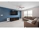 Inviting living room featuring a leather sofa, television, and neutral decor with natural light at 3990 Bannock Ave, Tavares, FL 32778