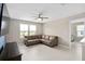Cozy living room with neutral decor, a leather sofa, and a view of the outdoors through bright windows at 3990 Bannock Ave, Tavares, FL 32778