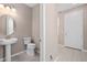 Convenient powder room featuring a pedestal sink, tile flooring, and natural color palette at 3990 Bannock Ave, Tavares, FL 32778