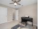 This room has two doors, gray tile floors, neutral paint, and a ceiling fan with piano and bench at 3990 Bannock Ave, Tavares, FL 32778