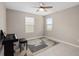 This room has two windows, gray tile floors, neutral paint, and a ceiling fan with piano and bench at 3990 Bannock Ave, Tavares, FL 32778