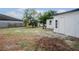 Spacious backyard showing a white-painted building, lush trees, and a wooden fence, perfect for outdoor activities at 4420 Lake Lawne Ave, Orlando, FL 32808