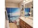 Clean bathroom features a double sink vanity, ocean themed shower curtain, and tile flooring at 4471 Treasure Cay Rd, Tavares, FL 32778