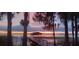 Sunset view of boat dock with a covered area and the lake reflecting the colorful sky at 4471 Treasure Cay Rd, Tavares, FL 32778