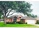 Charming single-story home with mature trees, well-manicured lawn, and a two-car garage at 4471 Treasure Cay Rd, Tavares, FL 32778