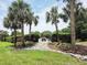 Neighborhood sign with palm trees, landscaped bushes, and manicured lawn at 4471 Treasure Cay Rd, Tavares, FL 32778