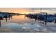 Picturesque waterfront marina view at sunset, featuring calm waters and moored boats reflecting the colorful sky at 4471 Treasure Cay Rd, Tavares, FL 32778