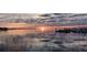 Scenic waterfront view featuring a serene sunset over the water and boats docked in the distance at 4471 Treasure Cay Rd, Tavares, FL 32778