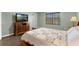 Bedroom with hardwood floors, a TV, large window, and a colorful quilt on the bed at 480 Buckhorn Dr, Winter Springs, FL 32708