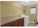 Well-lit laundry room with cabinets, counter space, and a modern washing machine at 480 Buckhorn Dr, Winter Springs, FL 32708