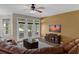Cozy living room featuring a TV, leather sofa, large windows, and access to the outdoors at 480 Buckhorn Dr, Winter Springs, FL 32708
