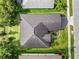 Aerial view of a well maintained house surrounded by trees, lawn, and a driveway at 4940 Tennessee Lake Dr, Auburndale, FL 33823