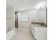 Bathroom with granite counters, separate tub and shower, and neutral tile flooring at 4940 Tennessee Lake Dr, Auburndale, FL 33823