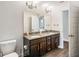 Bathroom featuring a double vanity with granite countertops and dark wood cabinets at 4940 Tennessee Lake Dr, Auburndale, FL 33823