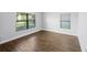 Bright bedroom with wood-look tile flooring and two windows providing natural light at 4940 Tennessee Lake Dr, Auburndale, FL 33823