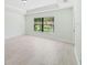 Bright bedroom features neutral tile flooring, a large window, and a tray ceiling at 4940 Tennessee Lake Dr, Auburndale, FL 33823