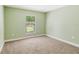 Neutral bedroom featuring carpeted floors, light green walls, and a bright window at 4940 Tennessee Lake Dr, Auburndale, FL 33823