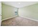 Simple bedroom design with carpet, light green walls and a window at 4940 Tennessee Lake Dr, Auburndale, FL 33823