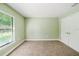 Bedroom with neutral carpet, window, and closet doors at 4940 Tennessee Lake Dr, Auburndale, FL 33823