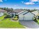 Beautiful single-Gathering home featuring a three-car garage, manicured lawn, and lush landscaping at 4940 Tennessee Lake Dr, Auburndale, FL 33823