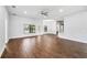 Open living room features wood-look tile flooring, ceiling fan, breakfast bar, and access to the backyard at 4940 Tennessee Lake Dr, Auburndale, FL 33823