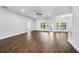 Spacious living room featuring wood flooring, a ceiling fan, plenty of windows, and bar seating at 4940 Tennessee Lake Dr, Auburndale, FL 33823