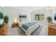 Serene primary bedroom with tray ceiling, neutral decor, and view to a large window at 4940 Tennessee Lake Dr, Auburndale, FL 33823