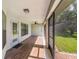 Covered patio with wood-look tile floors, ceiling fan, screen enclosure and view of the manicured backyard at 4940 Tennessee Lake Dr, Auburndale, FL 33823