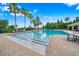 An inviting community pool with palm trees, lounge chairs, and tables for relaxation at 4940 Tennessee Lake Dr, Auburndale, FL 33823