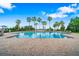 A large community pool featuring lounge chairs, palm trees, and a beautiful water view at 4940 Tennessee Lake Dr, Auburndale, FL 33823