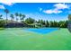 Brightly colored tennis court in a community with mature trees and a covered gazebo at 4940 Tennessee Lake Dr, Auburndale, FL 33823