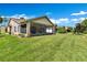Expansive lawn and screened-in lanai create a perfect outdoor living space with lush landscaping at 561 Vineyard Way, Poinciana, FL 34759
