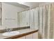 Bathroom featuring a large mirror, a single sink vanity, and a shower with a leafy-patterned curtain at 561 Vineyard Way, Poinciana, FL 34759
