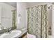 Bathroom with blue patterned shower curtain, single sink with countertop, and a shower at 561 Vineyard Way, Poinciana, FL 34759