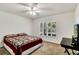Cozy bedroom with neutral carpet, a ceiling fan, plantation shutters, and a red, white, and blue quilt on the bed at 561 Vineyard Way, Poinciana, FL 34759