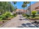 Elegant clubhouse entrance with manicured landscaping and a welcoming walkway lined with palm trees at 561 Vineyard Way, Poinciana, FL 34759