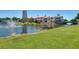 Picturesque view of a waterfront property featuring a fountain, bridge, and lush greenery at 561 Vineyard Way, Poinciana, FL 34759