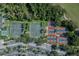 Aerial view of tennis courts and parking, surrounded by trees, providing a vibrant recreational space at 561 Vineyard Way, Poinciana, FL 34759
