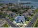 Aerial view of a luxury home with a blue roof, circular driveway, and stunning lake views at 5708 Emerington Cres, Orlando, FL 32819