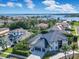 Aerial view of a luxury home with a blue roof, circular driveway, and stunning lake views at 5708 Emerington Cres, Orlando, FL 32819