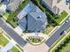 Aerial view of a modern house with a dark roof, landscaped yard, and a private screened-in pool at 5708 Emerington Cres, Orlando, FL 32819
